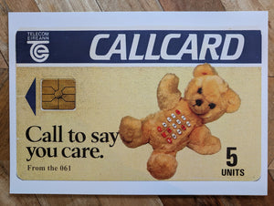 Callcard with teddy bear design and text on a wooden surface