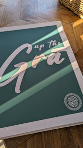 A turquoise and white print that reads "Up the Grá".